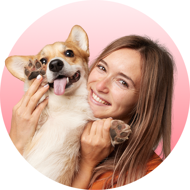 Woman smiling and hugging her corgi.