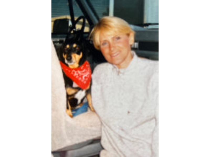 Woman and dog in car, red bandana.