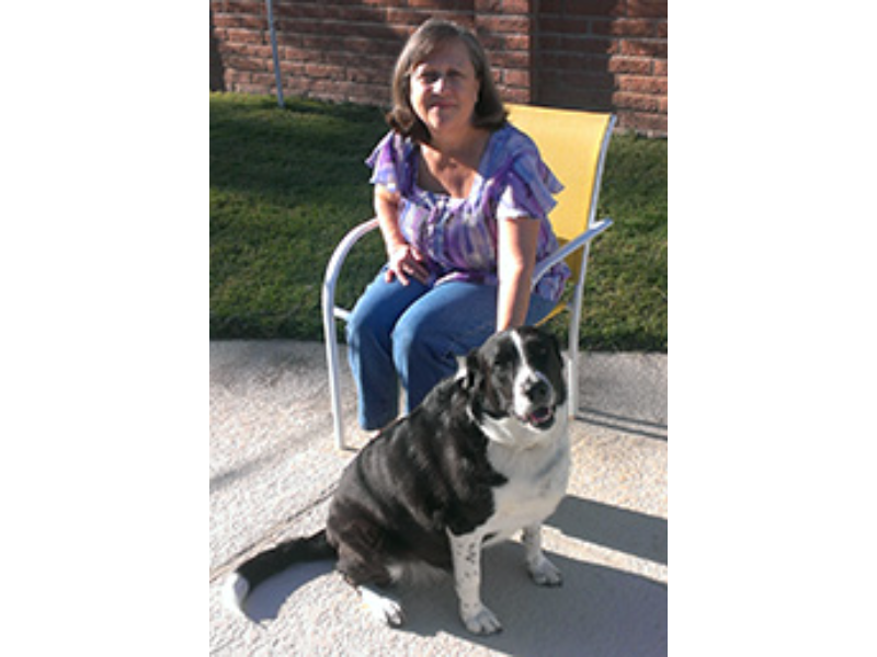 Woman sitting with her black and white dog.