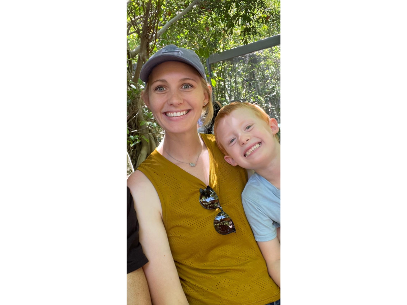 Smiling woman and child outdoors.