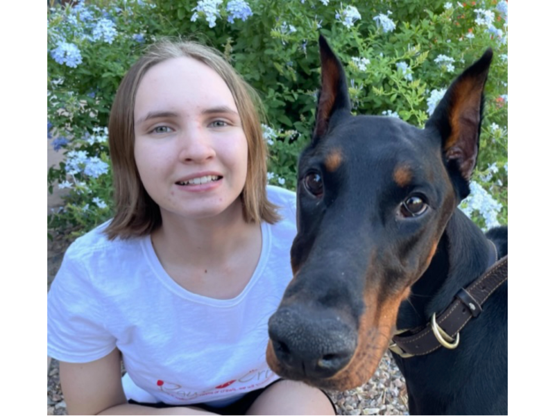 Woman smiling with her Doberman Pinscher.