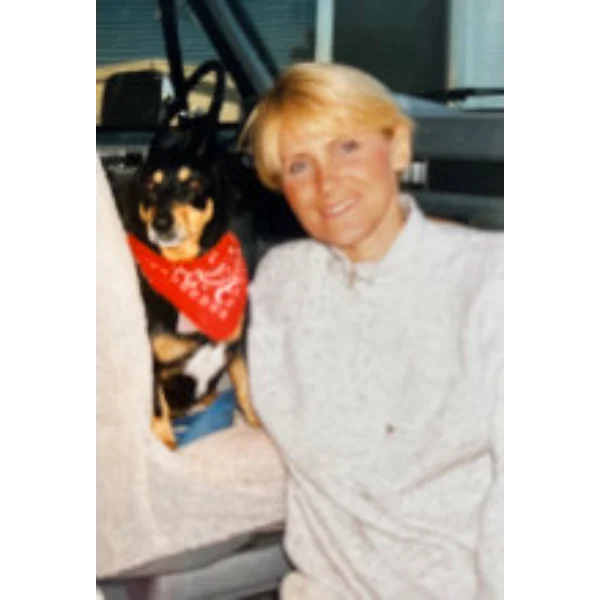 Woman and dog in car, red bandana.