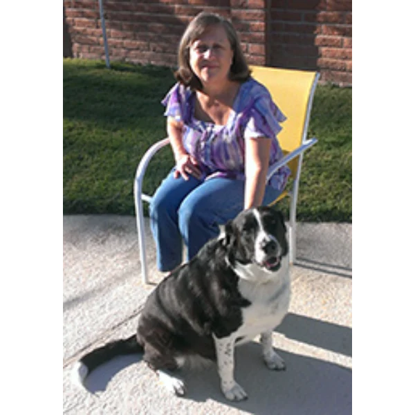 Woman sitting with her black and white dog.