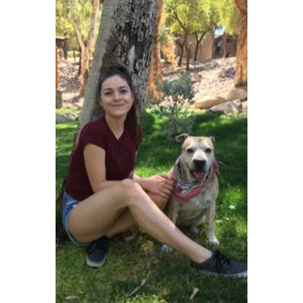Woman sitting with her dog outdoors.