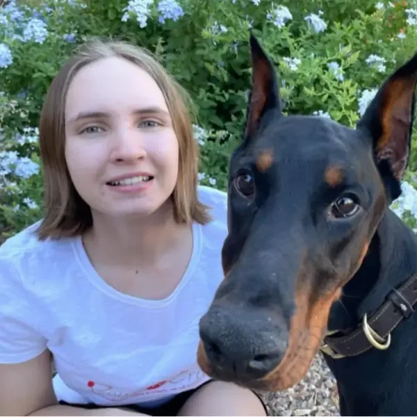 Woman smiling with her Doberman Pinscher.